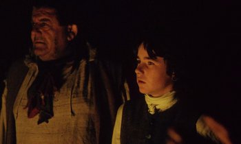 Movie still from “Black Jack” (1979), directed by Ken Loach – A man and a woman standing next to each other in the dark; Medium shot, Over the shoulder angle