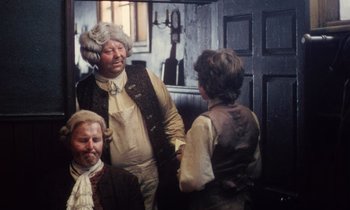 Movie still from “Black Jack” (1979), directed by Ken Loach – A group of people standing next to each other in a room; Medium shot, Over the shoulder angle