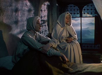 Movie still from “Black Narcissus” (1947), directed by Emeric Pressburger – Two women dressed as nuns sitting on a bed; Wide shot, High angle
