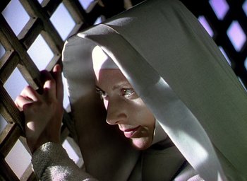 Movie still from “Black Narcissus” (1947), directed by Emeric Pressburger – A woman in a nun's outfit looking at the camera; Close Up shot, Low angle