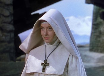Movie still from “Black Narcissus” (1947), directed by Emeric Pressburger – A woman in a nun's outfit with a cross on her head; Close Up shot, High angle