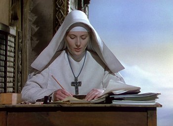 Movie still from “Black Narcissus” (1947), directed by Emeric Pressburger – A woman in a nun's outfit writing on a book; Medium shot, Low angle