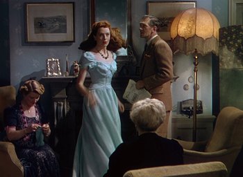 Movie still from “Black Narcissus” (1947), directed by Emeric Pressburger – A woman in a blue dress standing in front of a man; Medium shot, Over the shoulder angle