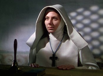 Movie still from “Black Narcissus” (1947), directed by Emeric Pressburger – A woman in a nun's outfit sitting at a table; Close Up shot, Low angle
