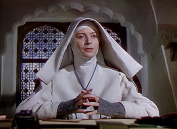 Movie still from “Black Narcissus” (1947), directed by Emeric Pressburger – A woman in a nun's outfit sitting at a table; Close Up shot, Low angle