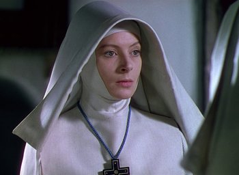 Movie still from “Black Narcissus” (1947), directed by Emeric Pressburger – A woman wearing a nun's outfit and a cross necklace; Close Up shot, Low angle