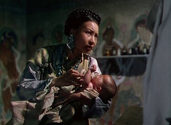 Movie still from “Black Narcissus” (1947), directed by Emeric Pressburger – A woman holding a baby in her arms; Medium shot, Low angle