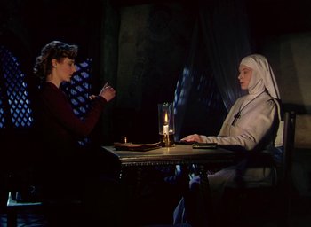 Movie still from “Black Narcissus” (1947), directed by Emeric Pressburger – Two women sitting at a table with a candle; Medium shot, High angle