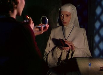 Movie still from “Black Narcissus” (1947), directed by Emeric Pressburger – A woman is looking at her cell phone in front of a nun; Close Up shot, Over the shoulder angle