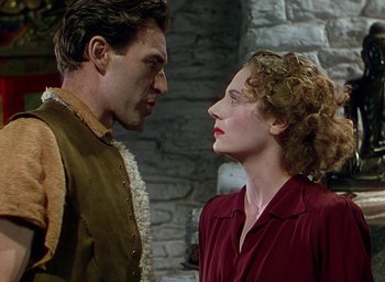 Movie still from “Black Narcissus” (1947), directed by Emeric Pressburger – A man and a woman face to face in front of a stone wall; Medium shot, Low angle