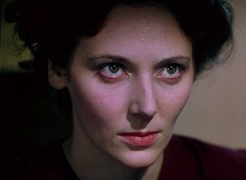 Movie still from “Black Narcissus” (1947), directed by Emeric Pressburger – A person's face in a dark room; Close Up shot, Over the shoulder angle