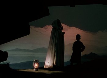 Movie still from “Black Narcissus” (1947), directed by Emeric Pressburger – Two people standing in front of an illuminated lantern; Wide shot, Low angle