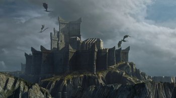 Movie still from “Game of Thrones” (2011), created by D.B. Weiss – A castle on top of a hill with a bunch of birds flying around; Extreme Wide shot, Low angle