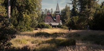 Movie still from “Dark” (2017), created by Baran bo Odar – An old church with a steeple in the middle of a field; Extreme Wide shot, Low angle