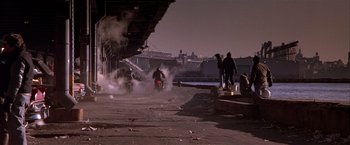 Movie still from “Black Rain” (1989), directed by Ridley Scott – A group of people standing around a motorcycle on a street; Wide shot, Low angle