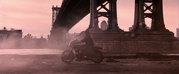 Movie still from “Black Rain” (1989), directed by Ridley Scott – A man riding a motorcycle under a bridge; Wide shot, Low angle