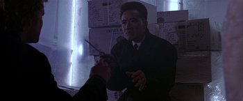 Movie still from “Black Rain” (1989), directed by Ridley Scott – A man holding a pair of shears in his hand; Close Up shot, Over the shoulder angle