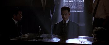 Movie still from “Black Rain” (1989), directed by Ridley Scott – A man sitting at a table in front of a mirror; Medium shot, Low angle