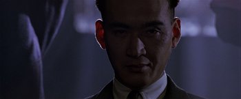 Movie still from “Black Rain” (1989), directed by Ridley Scott – A person wearing a suit and tie; Close Up shot, Low angle