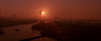 Movie still from “Black Rain” (1989), directed by Ridley Scott – The sun is setting over a body of water; Extreme Wide shot, High angle