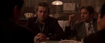 Movie still from “Black Rain” (1989), directed by Ridley Scott – A person sitting at a table; Medium shot, Over the shoulder angle