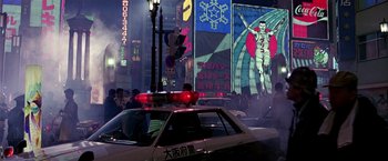 Movie still from “Black Rain” (1989), directed by Ridley Scott – A police car parked on the side of the street; Extreme Wide shot, Low angle