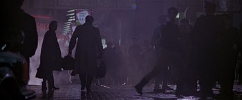 Movie still from “Black Rain” (1989), directed by Ridley Scott – A group of people walking down a street at night; Wide shot, Low angle