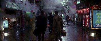Movie still from “Black Rain” (1989), directed by Ridley Scott – A group of people walking down a street at night; Wide shot, Low angle