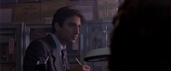 Movie still from “Black Rain” (1989), directed by Ridley Scott – A man in a suit and tie holding a pen; Close Up shot, Low angle