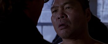 Movie still from “Black Rain” (1989), directed by Ridley Scott – A person with his eyes closed crying; Close Up shot, Over the shoulder angle