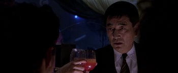 Movie still from “Black Rain” (1989), directed by Ridley Scott – A man and a woman sitting at a table with drinks; Close Up shot, Low angle