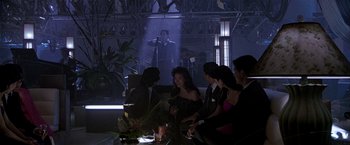 Movie still from “Black Rain” (1989), directed by Ridley Scott – A group of people sitting around a table in front of a projector screen; Wide shot, Over the shoulder angle