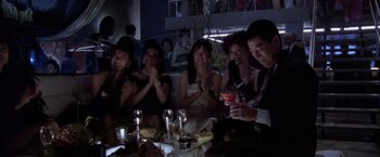 Movie still from “Black Rain” (1989), directed by Ridley Scott – A group of people sitting at a table with wine glasses; Medium shot, High angle