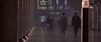 Movie still from “Black Rain” (1989), directed by Ridley Scott – Two men on a motorcycle in a building; Wide shot, Over the shoulder angle