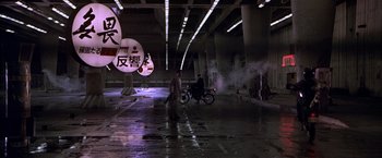 Movie still from “Black Rain” (1989), directed by Ridley Scott – Two men on a motorcycle in an underpass at night; Extreme Wide shot, Low angle