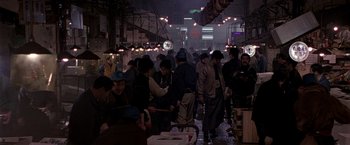 Movie still from “Black Rain” (1989), directed by Ridley Scott – A group of people standing around in an open area; Wide shot, High angle
