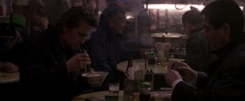 Movie still from “Black Rain” (1989), directed by Ridley Scott – A group of people sitting at a table eating food; Medium shot, Over the shoulder angle
