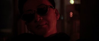 Movie still from “Black Rain” (1989), directed by Ridley Scott – A young man wearing a pair of sun glasses; Close Up shot, Low angle