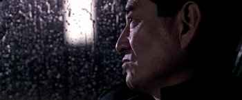 Movie still from “Black Rain” (1989), directed by Ridley Scott – A man's face in front of a window; Close Up shot, Low angle