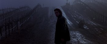 Movie still from “Black Rain” (1989), directed by Ridley Scott – A man standing on the side of a road in the dark; Medium shot, Low angle