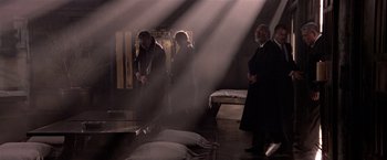 Movie still from “Black Rain” (1989), directed by Ridley Scott – A group of people standing in a dimly - lit room; Wide shot, High angle