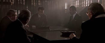 Movie still from “Black Rain” (1989), directed by Ridley Scott – A group of men sitting at a table in a room; Medium shot, High angle