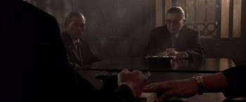Movie still from “Black Rain” (1989), directed by Ridley Scott – A group of men sitting at a table in front of a mirror; Medium shot, Over the shoulder angle