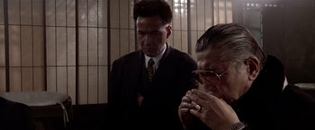 Movie still from “Black Rain” (1989), directed by Ridley Scott – A man in a suit and a woman in a suit and glasses; Close Up shot, Over the shoulder angle