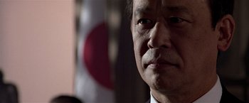 Movie still from “Black Rain” (1989), directed by Ridley Scott – A man's face in front of a japanese flag; Close Up shot, Low angle