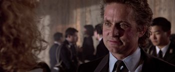 Movie still from “Black Rain” (1989), directed by Ridley Scott – A person wearing a suit and tie; Close Up shot, Over the shoulder angle