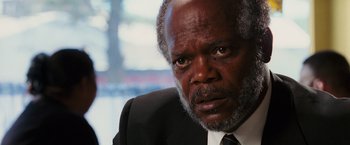 Movie still from “Black Snake Moan” (2006), directed by Craig Brewer – An older man wearing a suit and tie looking at the camera; Close Up shot, Over the shoulder angle