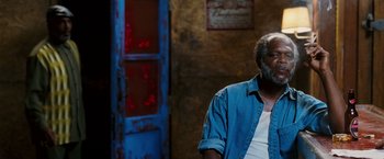 Movie still from “Black Snake Moan” (2006), directed by Craig Brewer – A man in a blue shirt is sitting in front of a door; Close Up shot, Over the shoulder angle