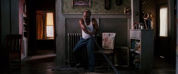 Movie still from “Black Snake Moan” (2006), directed by Craig Brewer – A man in a white tank top holding onto a chain; Wide shot, Low angle