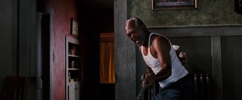 Movie still from “Black Snake Moan” (2006), directed by Craig Brewer – An older man in a white tank top is playing a video game; Medium shot, Low angle